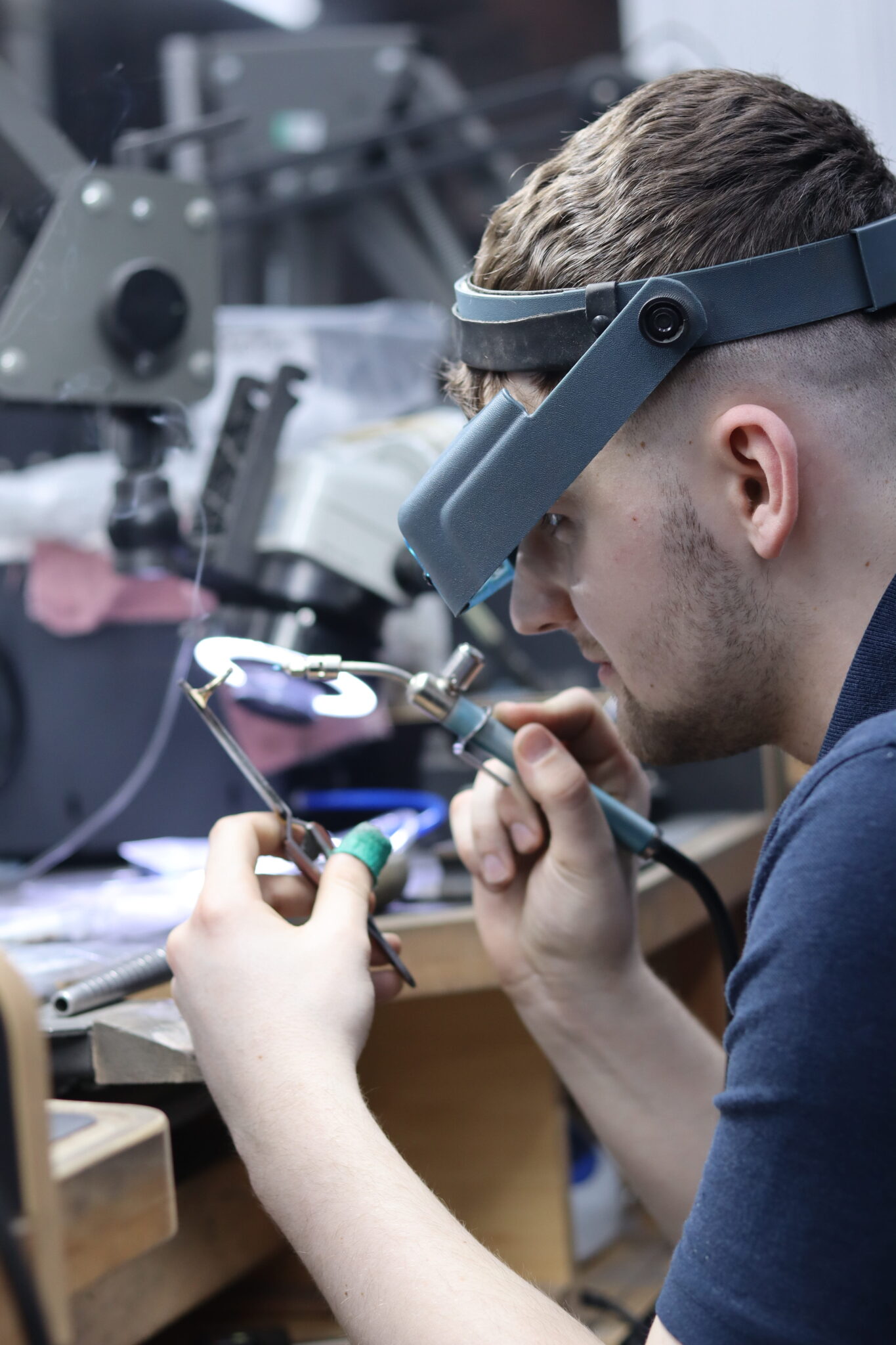 Jeweller at the Harkness Premier Jewellers workshop bench using magnification loupes to perform detailed repair work